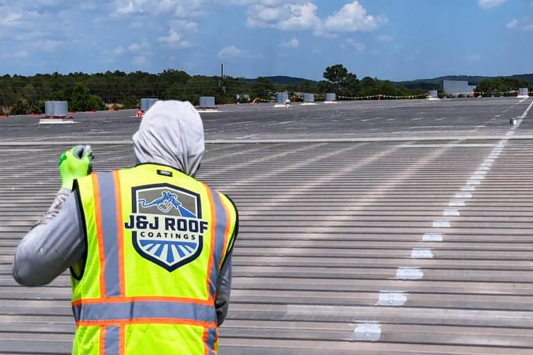 Roofing crew applying protective roof coating.